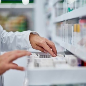 Male Pharmacist Choosing Medicine In A Drawer
