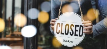 Woman putting a closed sign