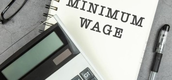 Minimum wage text on note pad with calculator.