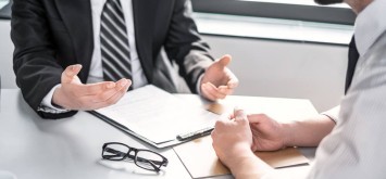 Business people negotiating a contract. Human hands working with documents at desk and signing contract.