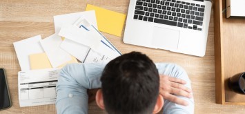 Top view of stressed man with lots of debts