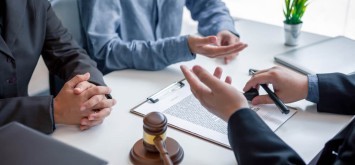 Businessman and lawyer discuss the contract document.