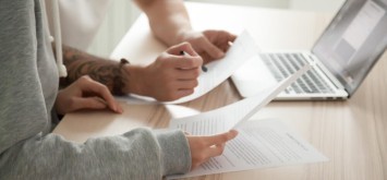 Close up view of hands holding papers.