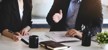 Consulting, male advisor pointed to company financials documents to restructure profitability of female entrepreneurs.