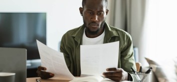 Male entrepreneur reading papers and business reports.